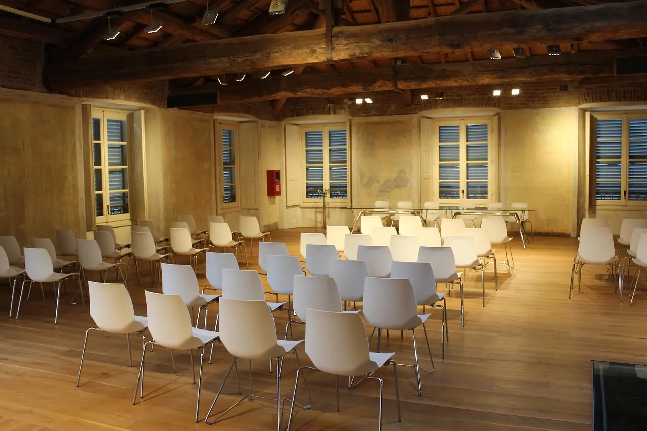 Sala szkoleniowa z rzędami krzeseł przygotowana do zajęć