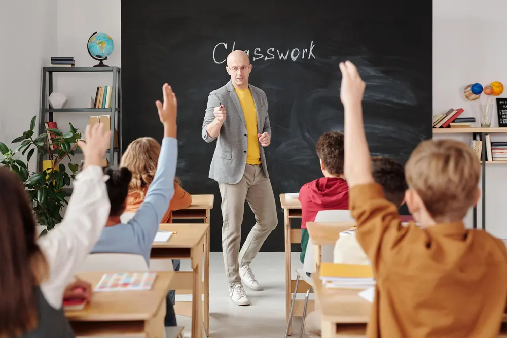 Uczniowie podnoszą ręce w klasie podczas lekcji